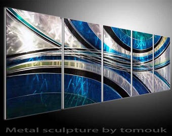 May include: Abstract metal wall art sculpture with a blue, silver and black colour scheme. The sculpture is made up of multiple panels that are joined together.