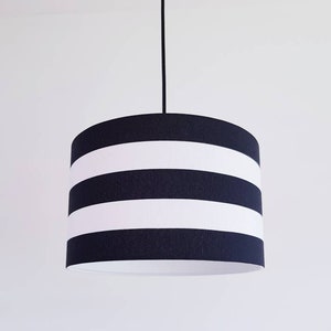 May include: A black and white striped pendant light fixture with a cylindrical shade.