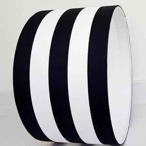 May include: Black and white striped lampshade with a cylindrical shape.
