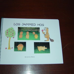 May include: A book cover with the title "Log Jammed Hog" and illustrations of a beaver, pigs, and a tree with apples. The book is by Cary D. Pierce.