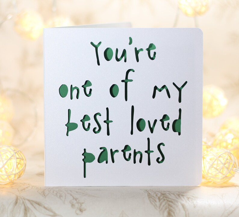 May include: A white card with the text "You're one of my best loved parents" written in green.