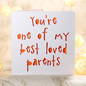May include: A white card with the text "You're one of my best loved parents" written in orange.