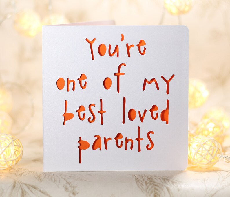 May include: A white card with the text "You're one of my best loved parents" written in orange.