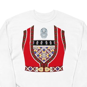 May include: White sweatshirt with a red and white embroidered vest design. The vest has a geometric pattern and a gold heart-shaped buckle.