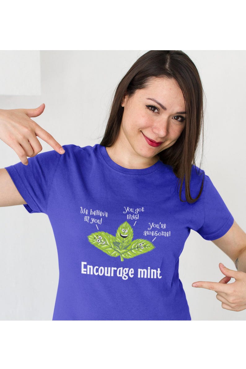 A woman points to a blue t-shirt printed with smiling mint leaves and the text Encourage mint.