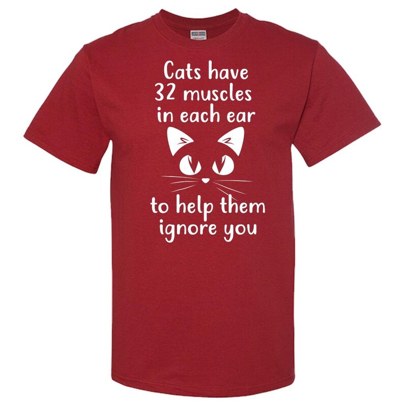 May include: Red t-shirt with a white cat illustration and the text "Cats have 32 muscles in each ear to help them ignore you."