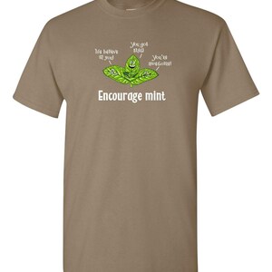 A tan or light brown t-shirt featuring a graphic of cute mint leaves and the text Encourage mint.