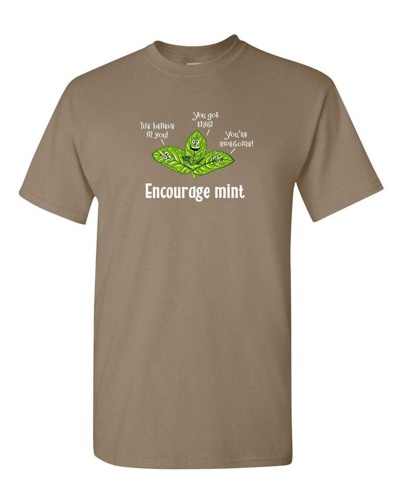 A tan or light brown t-shirt featuring a graphic of cute mint leaves and the text Encourage mint.