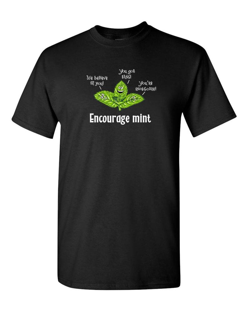 A black t-shirt displayed flat featuring an illustration of smiling mint leaves and the text Encourage mint.