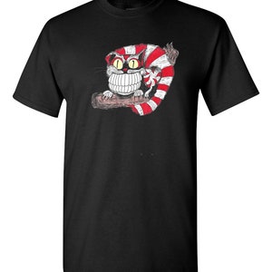 May include: Black t-shirt with a white and red striped Cheshire Cat illustration. The cat has a wide grin and large, yellow eyes.