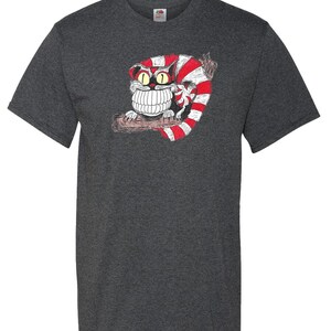 May include: A dark heather grey t-shirt with a cartoon Cheshire Cat graphic. The cat is red and white striped and has a large grin with sharp teeth.