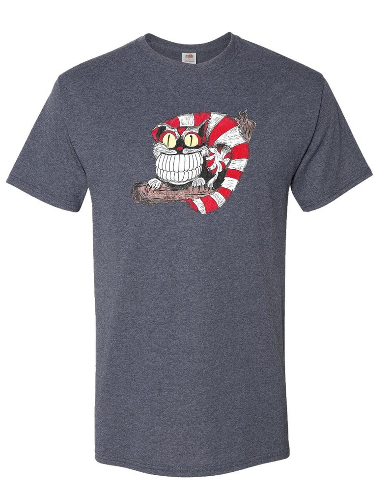 May include: A heather gray t-shirt with a cartoon illustration of a Cheshire Cat with a wide grin and red and white stripes. The cat is sitting on a branch.