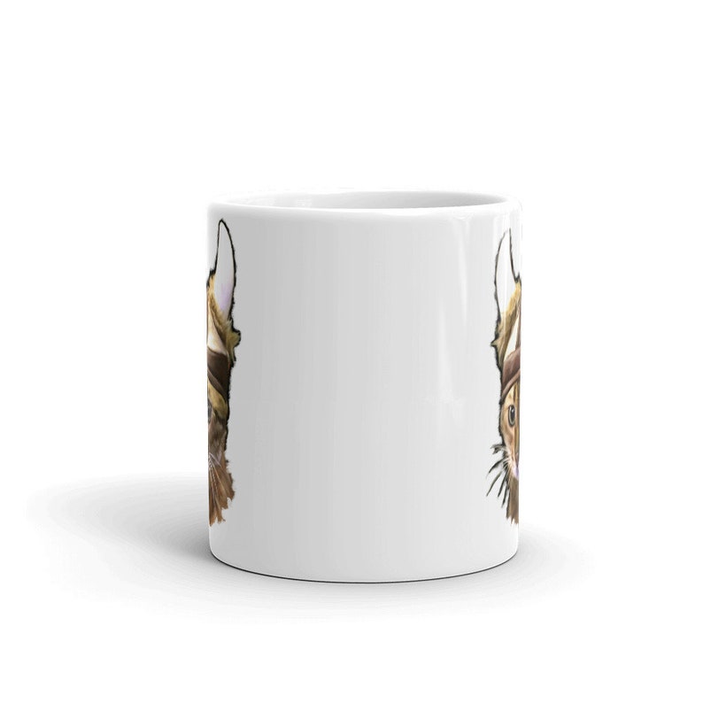 May include: White ceramic mug with a brown and white cat wearing a viking helmet printed on both sides.