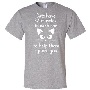 May include: Gray t-shirt with a white cat silhouette and the text "Cats have 32 muscles in each ear to help them ignore you."