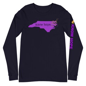 Peut inclure: T-shirt &agrave; manches longues bleu marine avec un contour violet de la Caroline du Nord et les mots "know hope". La manche droite porte les mots "KNOW HOPE" en violet. Des papillons dor&eacute;s sont pr&egrave;s de la c&ocirc;te de l'&Eacute;tat.