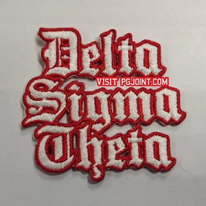 May include: Embroidered patch featuring the words "Delta Sigma Theta" in a gothic font. The text is white with a red border. The website "VISIT PGJOINT.COM" is also visible.