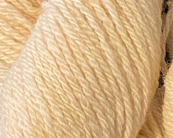 Könnte beinhalten: Nahaufnahme eines Strangs cremefarbener Wolle. Das Garn ist eng gewickelt und zeigt einzelne Stränge mit einer strukturierten Oberfläche. Die Farbe ist ein weiches, warmes Off-White, ideal für Strick- oder Häkelprojekte.