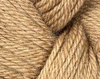 Könnte beinhalten: Nahaufnahme eines Knäuels beigefarbener Wolle. Das Garn ist eng gewickelt und zeigt die Textur der Fasern. Die Farbe ist ein warmer, neutraler Ton, der für verschiedene Strick- und Häkelprojekte geeignet ist. Ideal für die Herstellung von Schals, Pullovern und anderen handgefertigten Artikeln.
