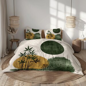 Peut inclure: Ensemble de housse de couette et d'oreillers crème avec un design botanique moderne. Le motif présente des formes abstraites vertes et dorées et des illustrations de plantes stylisées. La literie est sur un lit avec une tête de lit en bois et un tapis rond en jute.