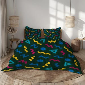 Peut inclure: Une housse de couette vert foncé et deux taies d'oreiller avec un motif répété de formes géométriques colorées. Les formes comprennent des cercles bleus, des zigzags jaunes, des zigzags roses et des triangles bleus et turquoise. La literie est sur un cadre de lit en bois.
