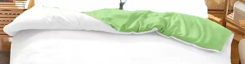 a bed with a green and white comforter