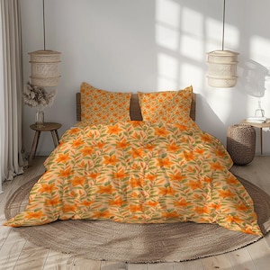 Puede incluir: Una cama con un juego de cama con estampado floral. El juego incluye una funda nórdica y dos fundas de almohada, todas con flores naranjas y hojas verdes sobre un fondo beige claro. La cama está sobre una alfombra redonda tejida.