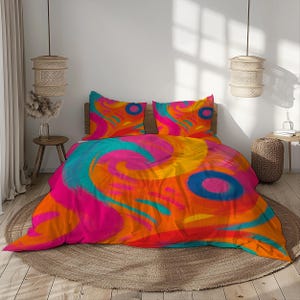Peut inclure: Un lit avec une parure de lit abstraite et vibrante. La housse de couette et les deux taies d'oreiller présentent un motif tourbillonnant dans des tons d'orange, de rose, de jaune et de bleu. Le lit est posé sur un tapis rond tissé, avec des luminaires suspendus décoratifs.