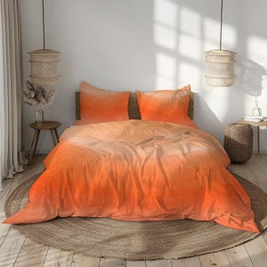 May include: An orange ombre bedding set featuring a duvet cover and two pillowcases. The color gradient transitions from a light peach to a vibrant orange. The bedding is displayed on a wooden bed frame, creating a warm and inviting aesthetic.