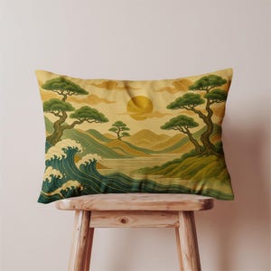 May include: A rectangular throw pillow featuring a printed landscape illustration with stylised green trees, rolling hills, and dark teal ocean waves. A large yellow sun sits in the centre of a pale golden sky with swirling cloud patterns.