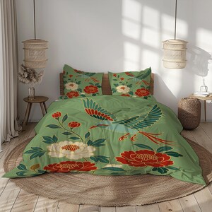 May include: Green duvet cover and pillowcases with a crane design in red, white, and blue. The bedding set also features large red and white floral patterns. The overall theme is a nature-inspired design.