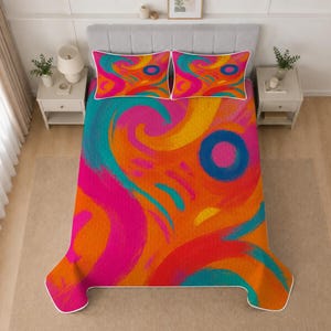 May include: A bed quilt and two matching pillow shams featuring a vibrant abstract pattern of swirling brushstrokes in bright orange, hot pink, teal, and yellow, with a prominent blue circle design on the pillows and a white piped edge.