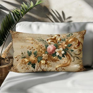 Peut inclure: Un coussin décoratif avec un motif floral composé de fleurs roses, blanches et jaunes avec des accents dorés sur un fond beige.