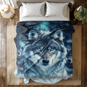 May include: A blue and white wolf blanket with a close-up of the wolf's face. The wolf has a serious expression and piercing blue eyes.