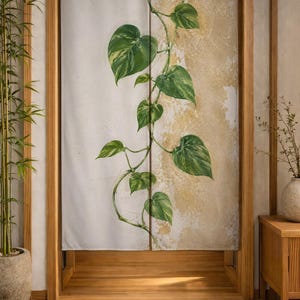 May include: A split fabric door curtain featuring a vertical trailing vine with green heart-shaped leaves. The background is divided into a solid light gray section on the left and a textured, mottled gold and cream finish on the right side.