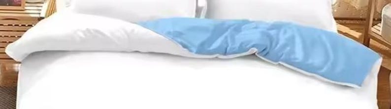 a bed with a blue and white comforter and pillows