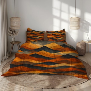 以下が含まれることがあります： オレンジ、茶色、グレーの色合いの山脈デザインの寝具セット。 セットには、掛け布団カバーと枕カバー2枚が含まれています。 寝具は、木製のヘッドボード、丸いラグ、2つのペンダントランプを備えたベッドに表示されています。