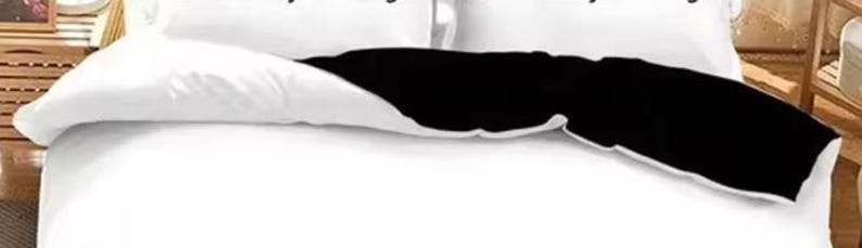 a bed with a black and white comforter and pillows