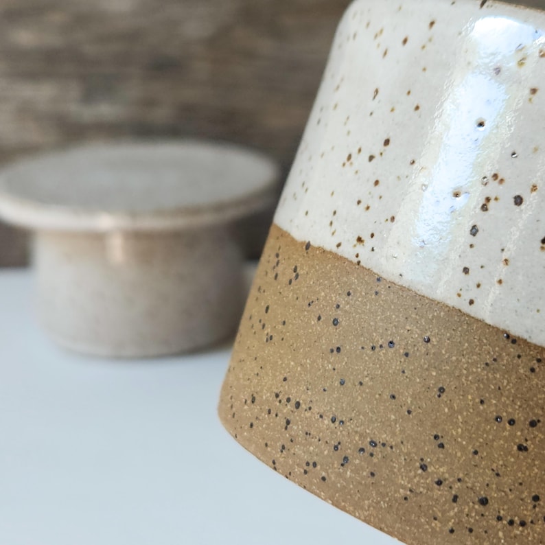 The unglazed portion has a slight texture and is located on the lower half of the  base cup exterior