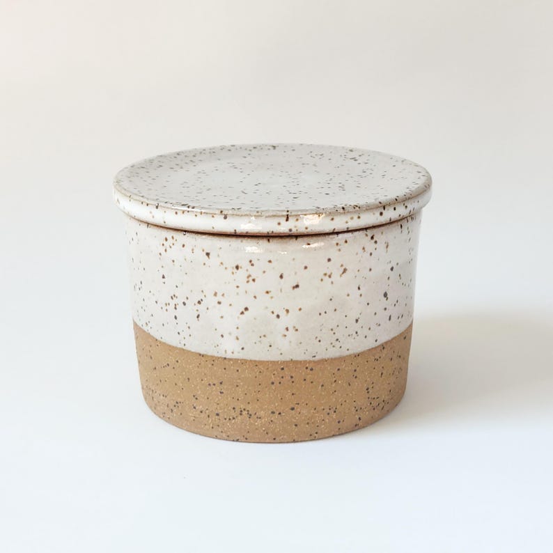 Handmade butter keeper is partially glazed in white.  The lower half has unglazed brown speckled clay.