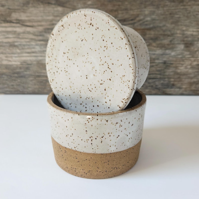 The handmade butter dish is made with speckled clay.  These speckles show through the food safe white glaze.