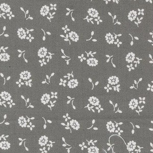 May include: A grey fabric with a white floral pattern. The fabric has a subtle texture and is ideal for quilting, sewing, and crafting.