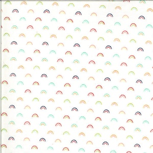 May include: White fabric with a repeating pattern of small, colourful rainbows. The fabric is measured with a ruler in inches.