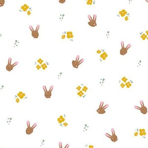 May include: White fabric with a repeating pattern of brown bunny faces and yellow flower clusters.