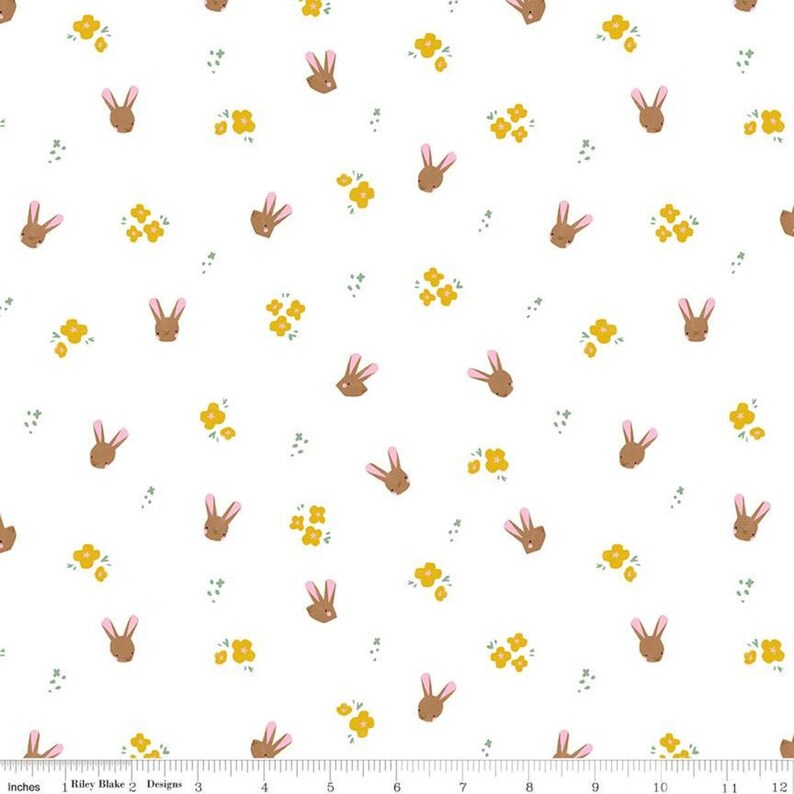 May include: White fabric with a repeating pattern of brown bunny faces and yellow flower clusters.