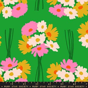 May include: A green fabric featuring a repeating pattern of flower bouquets in pink, white, and mustard yellow. The bottom edge includes a black selvage strip with the white text Ruby Star Society and a ruler measuring up to 18 cm.