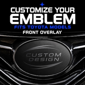 May include: A black oval front emblem overlay for Toyota vehicles. The text CUSTOMIZE YOUR EMBLEM FITS TOYOTA MODELS FRONT OVERLAY appears in white and blue. The center of the emblem features the words CUSTOM DESIGN in dark gray.