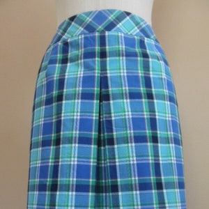 May include: A blue, green, and white plaid skirt with pleats. The skirt is knee-length and has a straight silhouette.