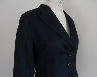 May include: A black linen blazer with a notched collar, three buttons, and a single pocket on the left side. The blazer is tailored and has a fitted silhouette.