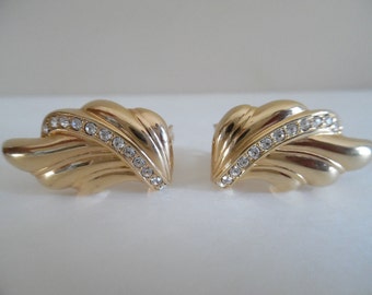 May include: A pair of gold tone earrings with a leaf design and clear rhinestone accents.