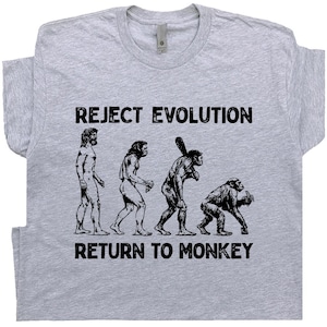May include: A light gray t-shirt with the text "REJECT EVOLUTION" above a black and white illustration of the evolution of man, ending with a monkey. Below the illustration is the text "RETURN TO MONKEY".